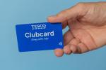 a person holding a blue tesco clubcard in their hand