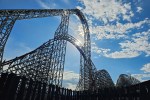 a roller coaster with the sun shining through it