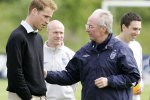 a man wearing an umbro jacket talks to another man