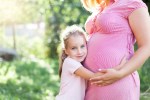 a little girl hugging a pregnant woman 's belly