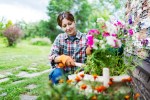 a woman wearing orange gloves is working in a garden